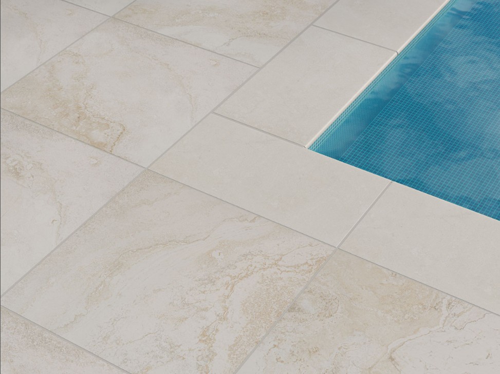 Livingstyle Travertino porcelain pavers elegantly surrounding a swimming pool, showcasing their water-resistant and slip-resistant qualities