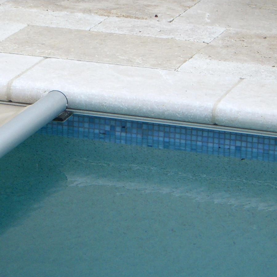 Close-up of traditional bullnose coping with its classic curved edge, offering a gentle, tactile border for safer, more comfortable poolside seating.