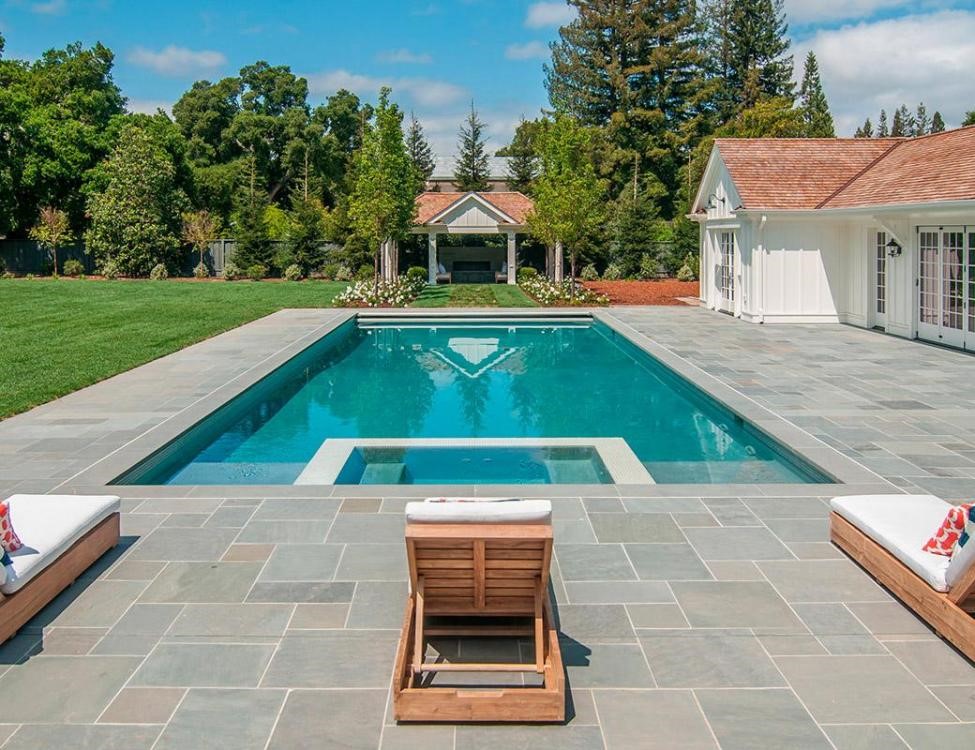 Sophisticated pool design featuring bluestone coping and an integrated hot tub, combining rustic charm with contemporary leisure facilities.