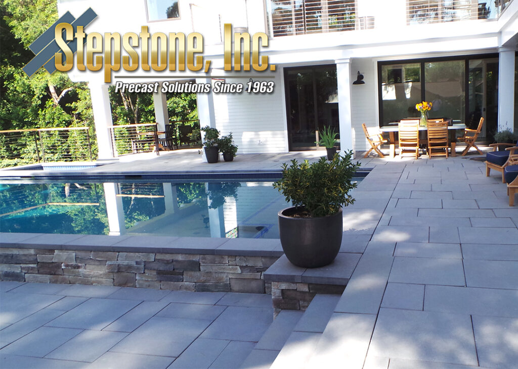 Stepstone Inc. precast pavers of various sizes around a back patio and pool, creating a visually striking and durable outdoor area perfect for modern landscaping designs.