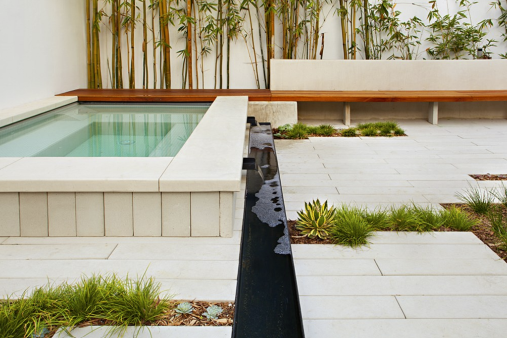 Alabaster concrete pavers surrounding a pool and serving as the pool coping, creating a seamless and elegant outdoor design with durable, low-maintenance Stepstone Inc. precast concrete solutions.