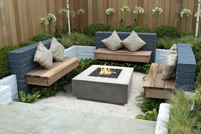Cozy outdoor fire pit with stone accent walls and rustic wood benches, ideal for evening gatherings.
