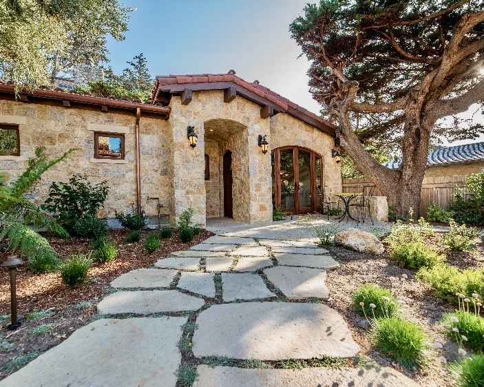 Charming house with a natural flagstone walkway leading to the front door, creating a welcoming and elegant entryway.