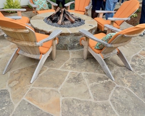 Cozy outdoor fire pit area surrounded by a flagstone patio, creating a warm and inviting space for gatherings.