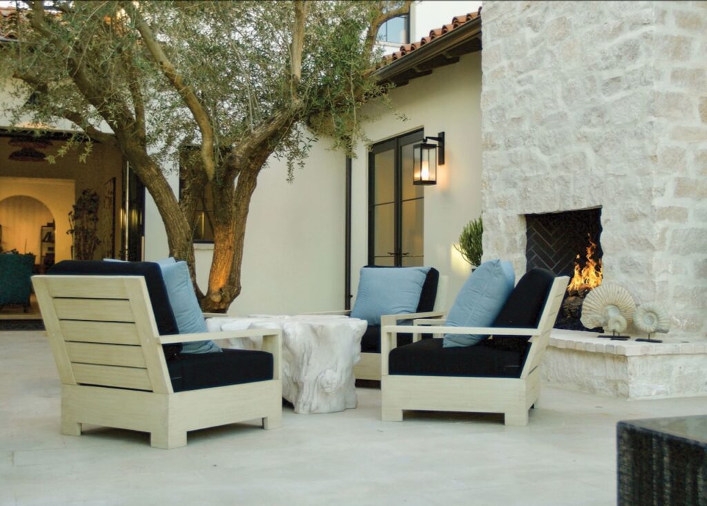 Elegant natural stone patio featuring plush seating and a modern stone fireplace, ideal for luxury outdoor living spaces.