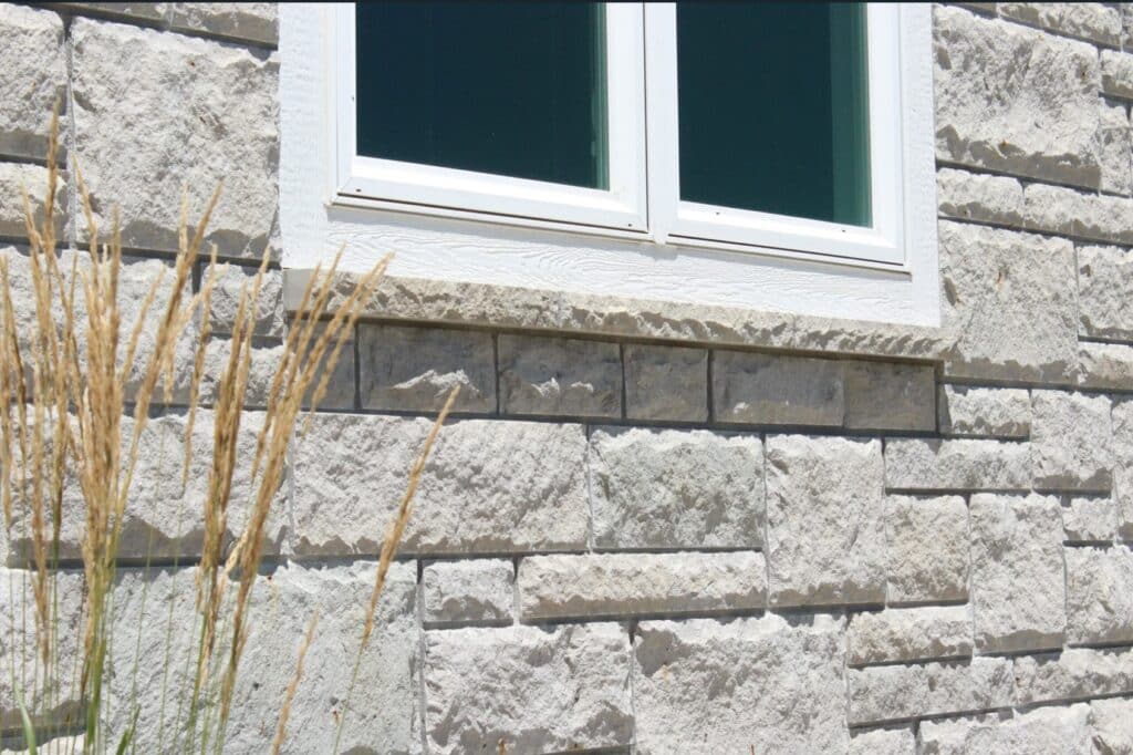 Rustic-style home exterior showcasing Flint Hills Gray Limestone with a split-face texture, creating a natural and rugged stone facade.