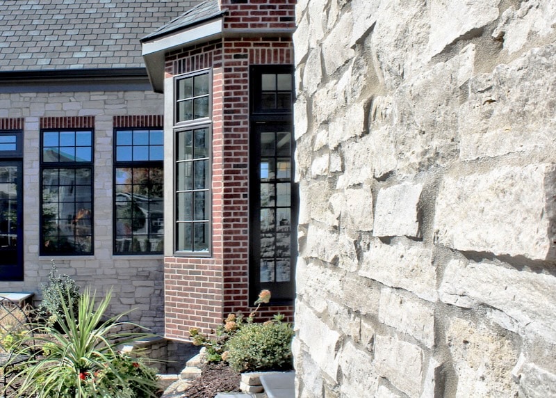 A home exterior featuring a combination of brick and natural stone veneer, showcasing fire-resistant materials for enhanced safety and timeless aesthetics.