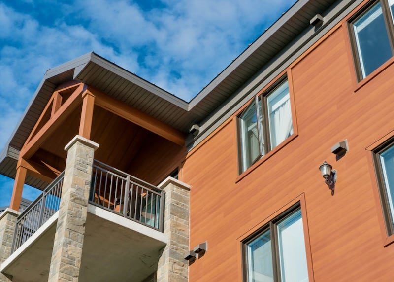 A contemporary home exterior featuring fire-resistant MAC Metal siding in a wood-look finish, providing both safety and an elegant architectural style.