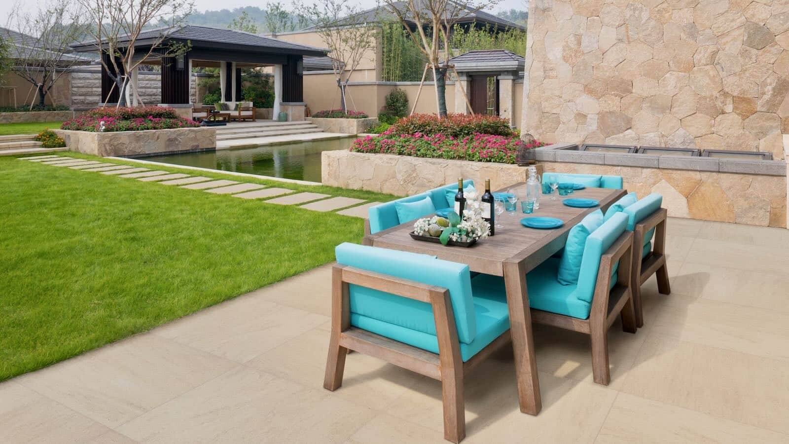 A luxurious outdoor living space featuring Landmark Porcelain pavers, sleek modern furniture, and a built-in fireplace, creating a seamless indoor-outdoor design.