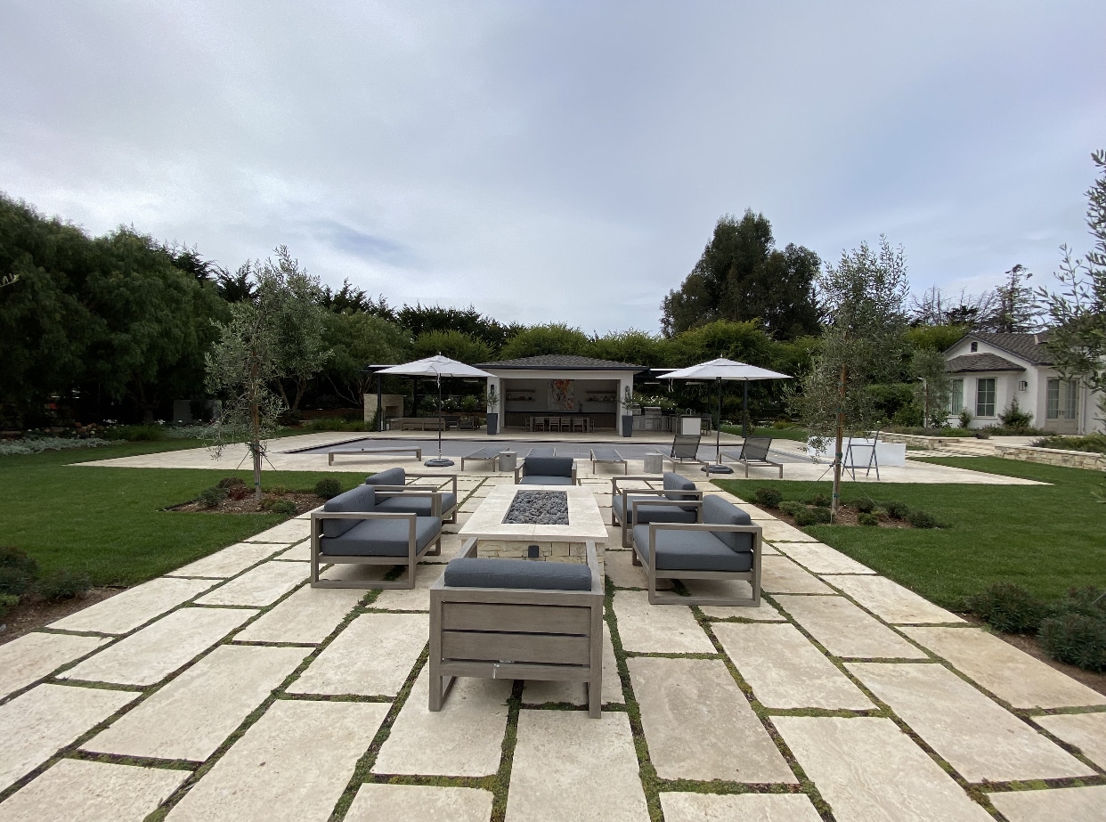 A stunning backyard retreat with a bluestone pool deck, crystal-clear water, and inviting lounge chairs, perfect for luxury outdoor living.