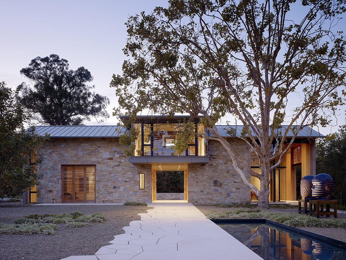 A breathtaking hillside poolside retreat featuring a custom natural stone patio, stunning valley views, and resort-style seating.