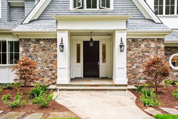 Contemporary residence with stone veneer exterior and wooden gate, showcasing timeless curb appeal.