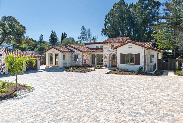 Large residential driveway paved with interlocking concrete pavers in a modular pattern.