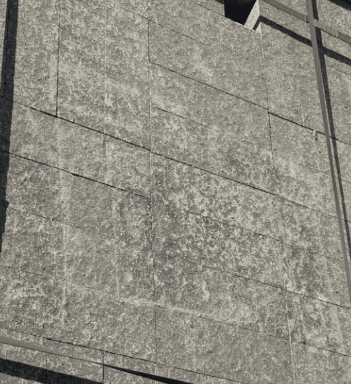 Close-up of Ebony Flame cobblestone pavers showing the charcoal-gray flamed texture and rectangular cobble layout on a pallet.