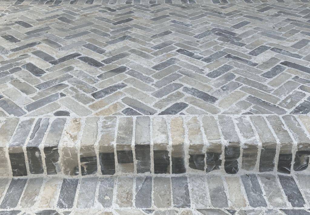 Lompoc cobblestone step/edge detail, highlighting the soldier-course border and textured stone surface.