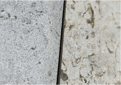 Close-up of two textured limestone pavers, one warm beige and one cool gray, showing subtle color and surface variation.