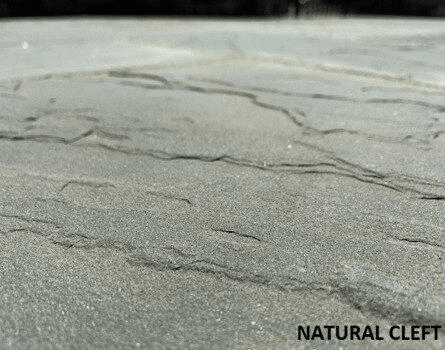 Detail of gray natural cleft stone surface with layered ridges and a softly textured finish labeled natural cleft.
